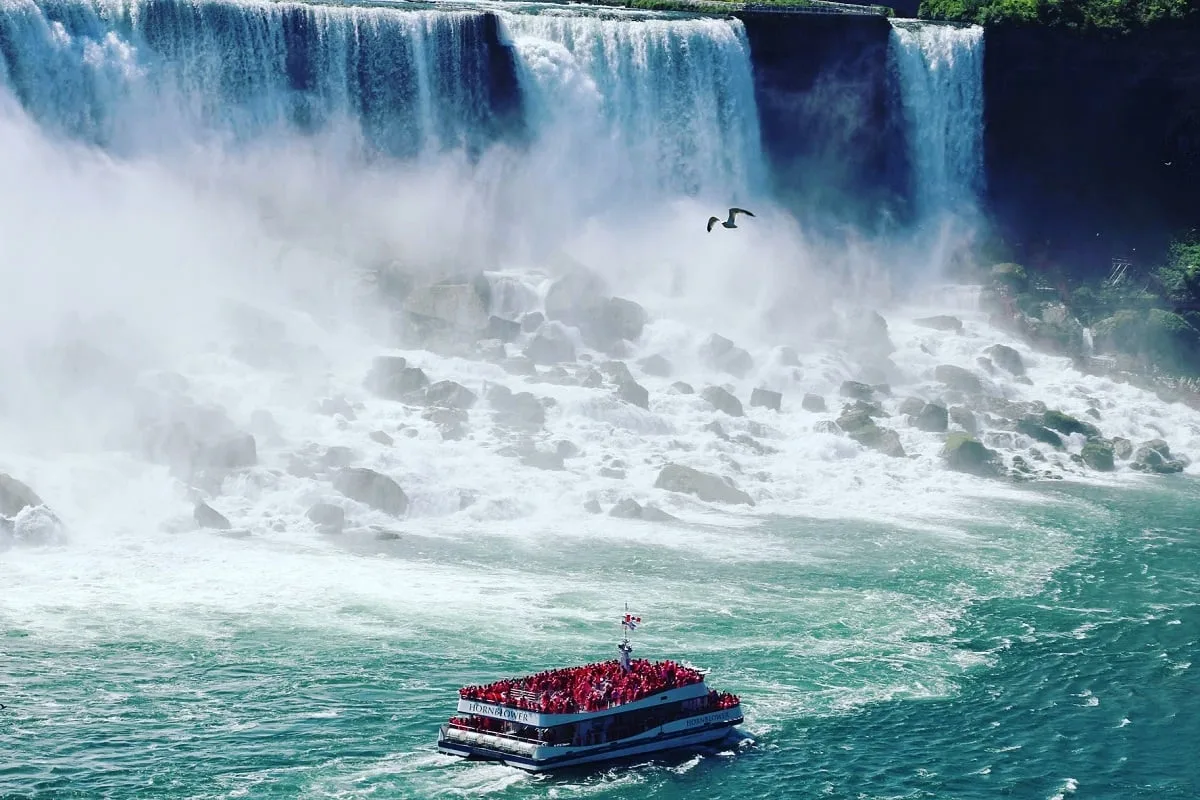 Bateau plein de passagers sous une chute