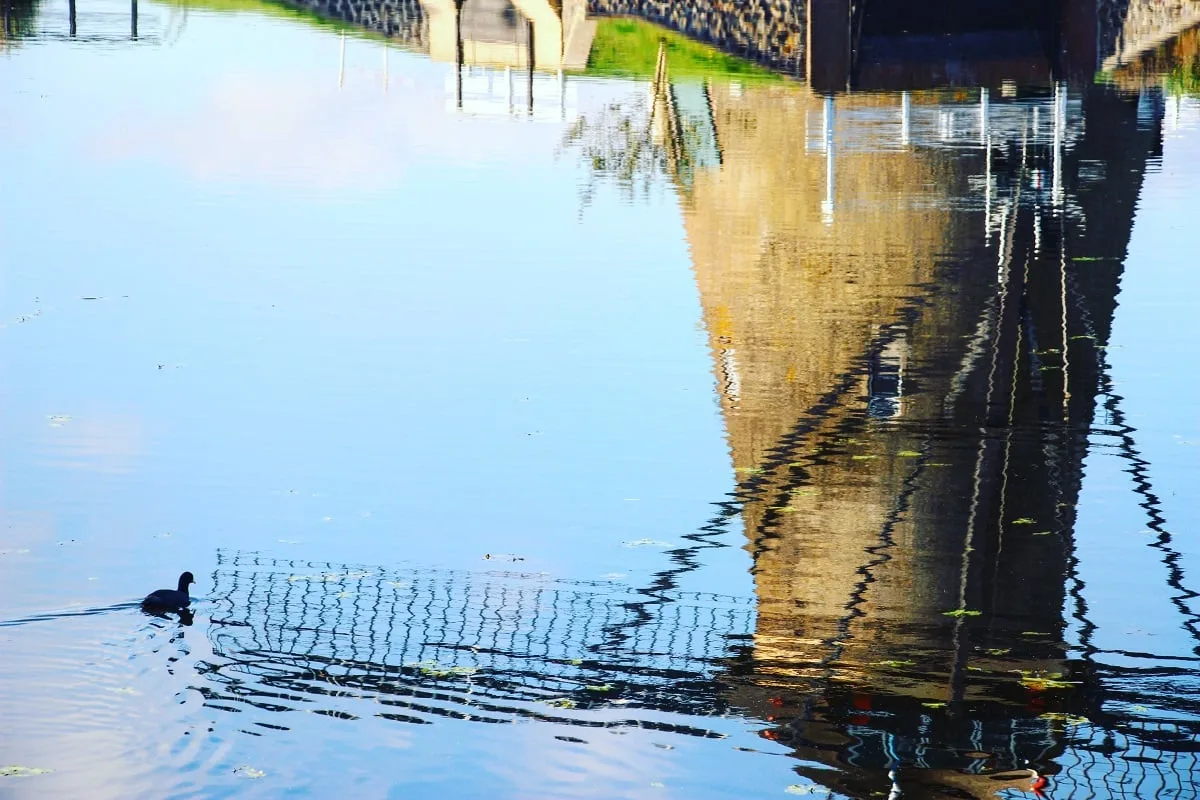 Réflection d'un moulin à vent dans le canal