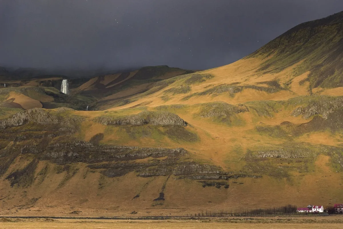 Paysage du sud de l'Islande qui illustre bien la météo : un ciel couvert mais un rayon de soleil qui illumine la montagne