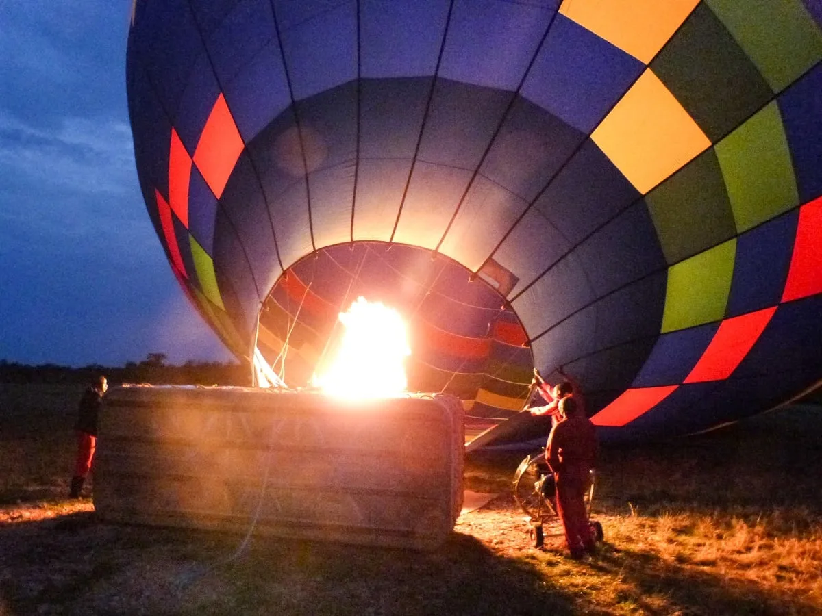 Personne qui gonfle une montgolfière au petit matin