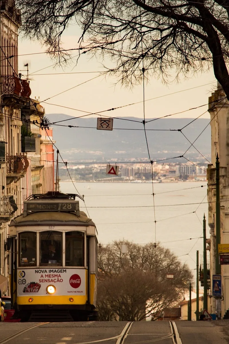 Tramway dans une rue en pente avec le Tage en arrière plan