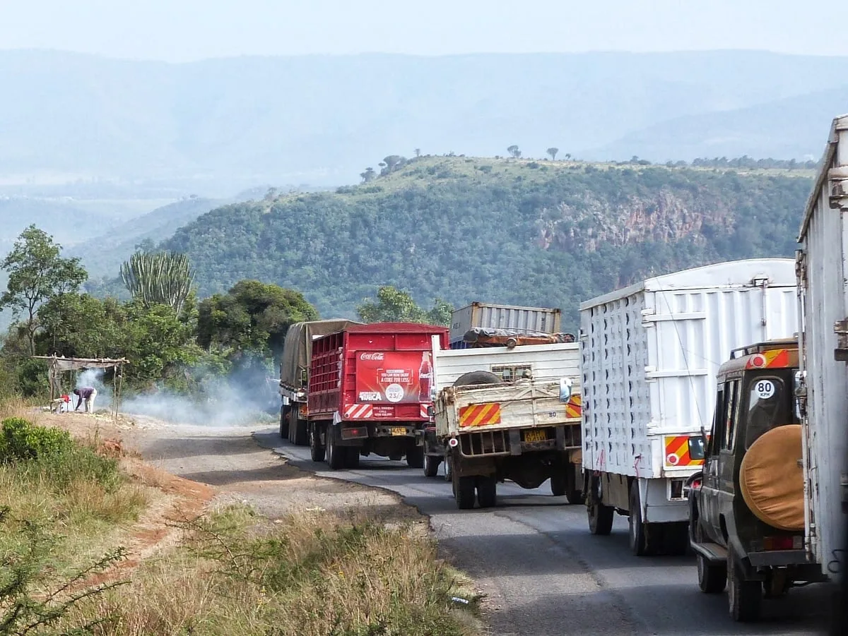 Camions qui se suivent sur une route principale, montagneuse
