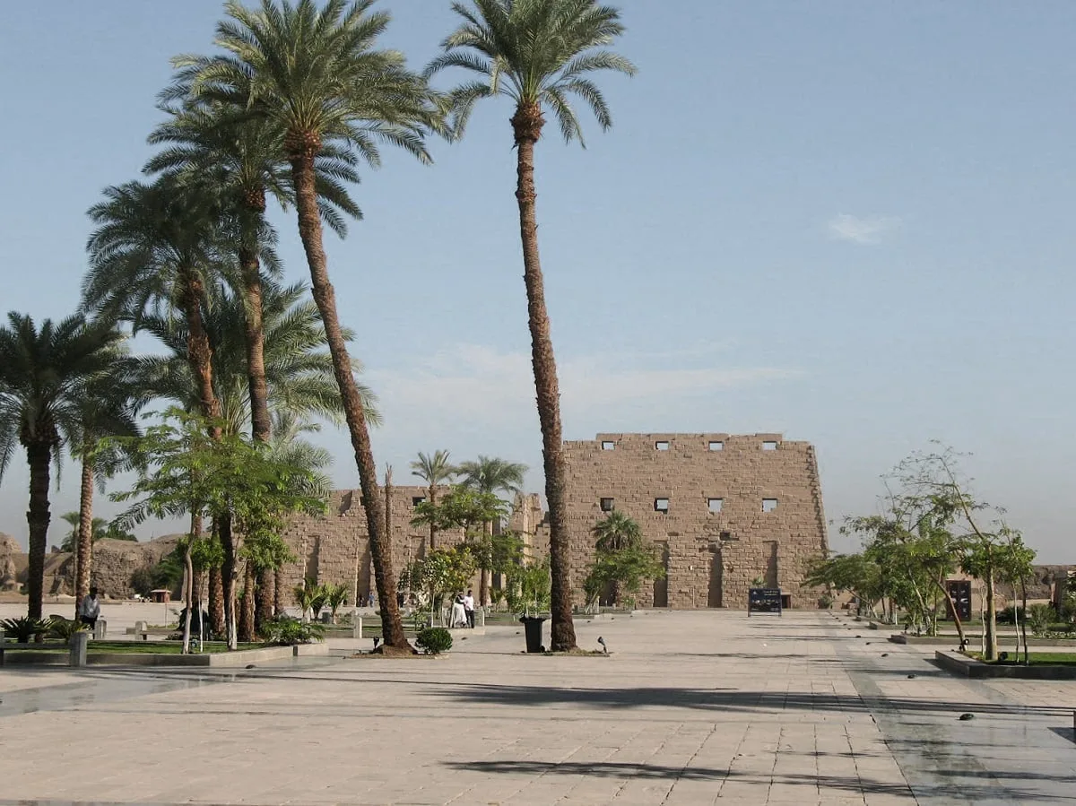 Le temple de Karnak au loin avec des palmiers au premier plan