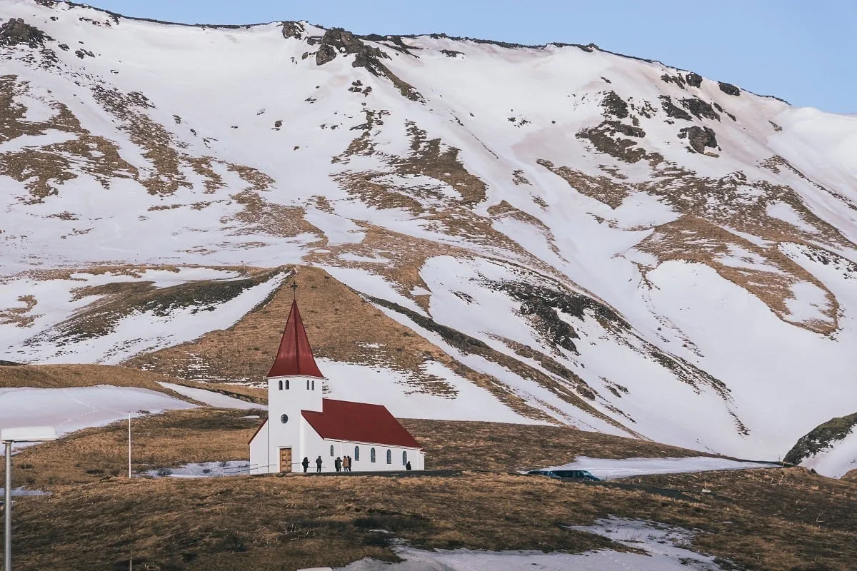 Eglise en hiver avec une montagne enneigée derrière