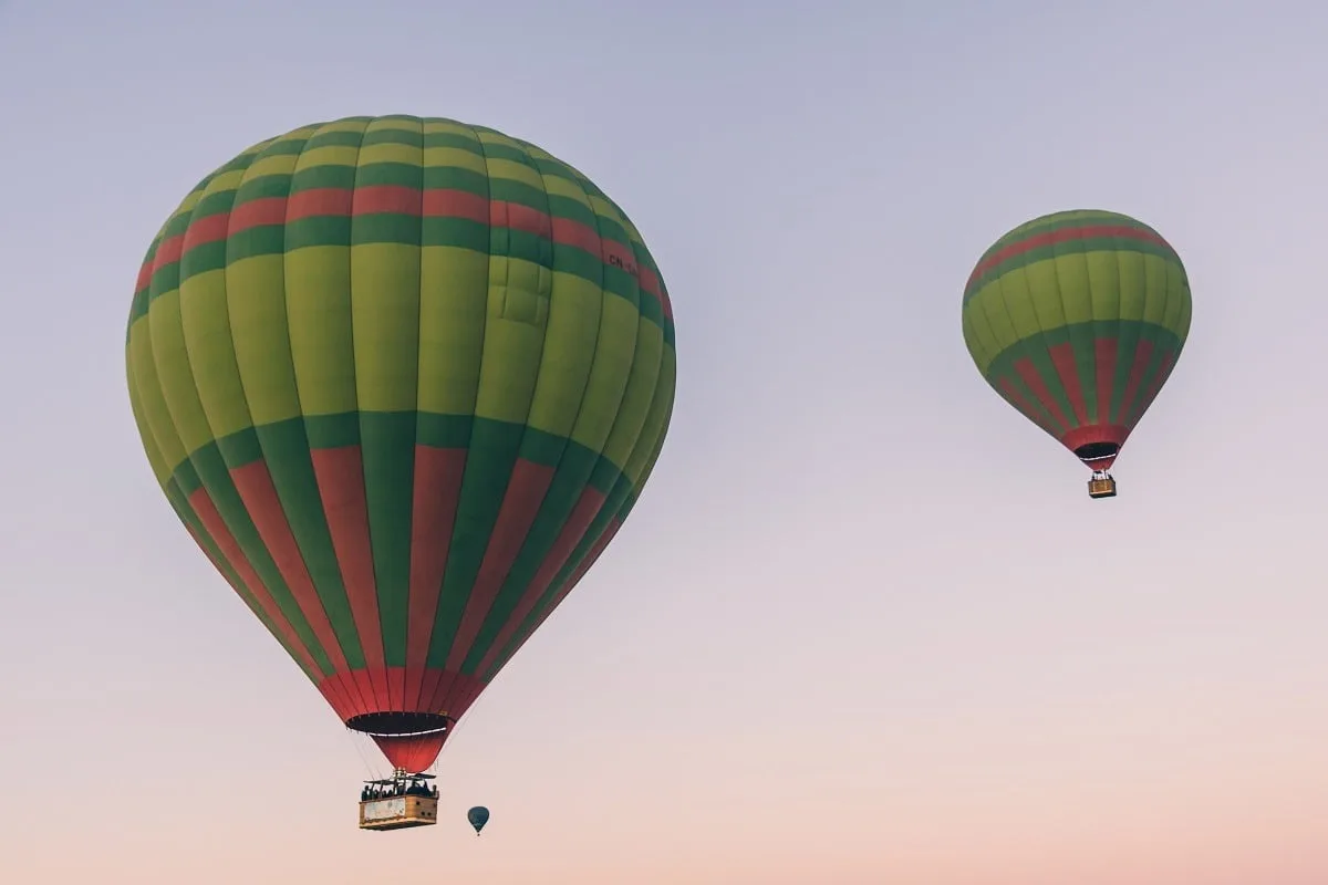Montgolfières dans les airs aux couleurs du lever du soleil