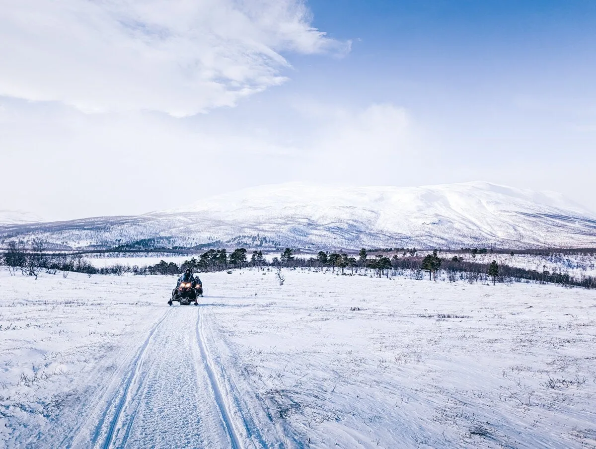 Sur la piste d'un motoneige avec les montagnes au fond
