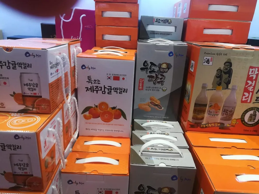 Boîtes cadeaux orange empilées avec inscriptions coréennes et mandarines