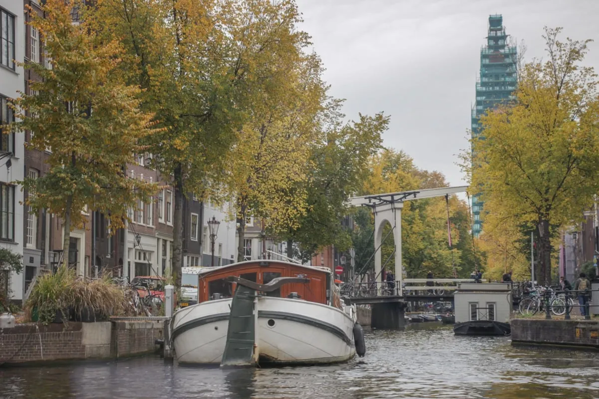 Péniche amarrée sur un canal bordé d'arbres aux couleurs automnales