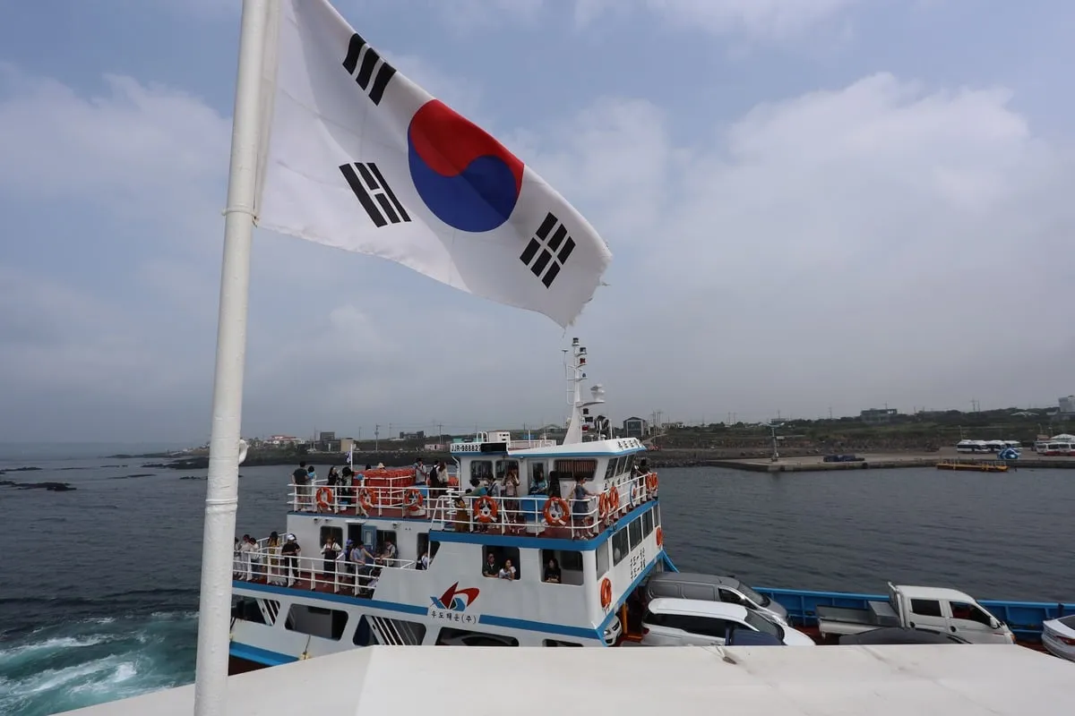 Drapeau coréen flottant sur un ferry chargé de passagers et véhicules