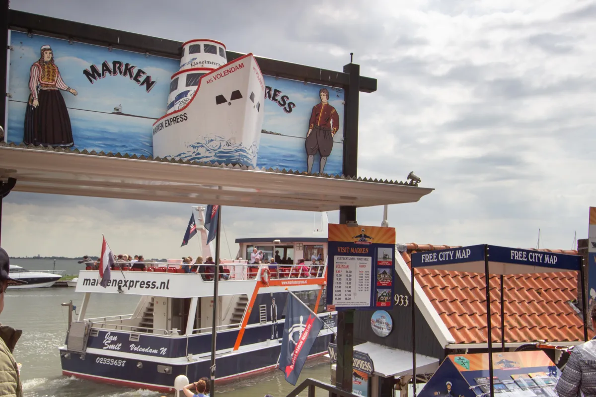 Embarcadère avec panneau touristique et ferry à quai