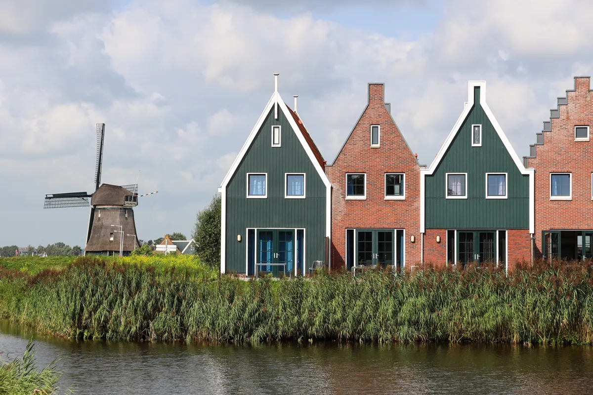 Maisons à pignons colorées et moulin à vent au bord d'un canal
