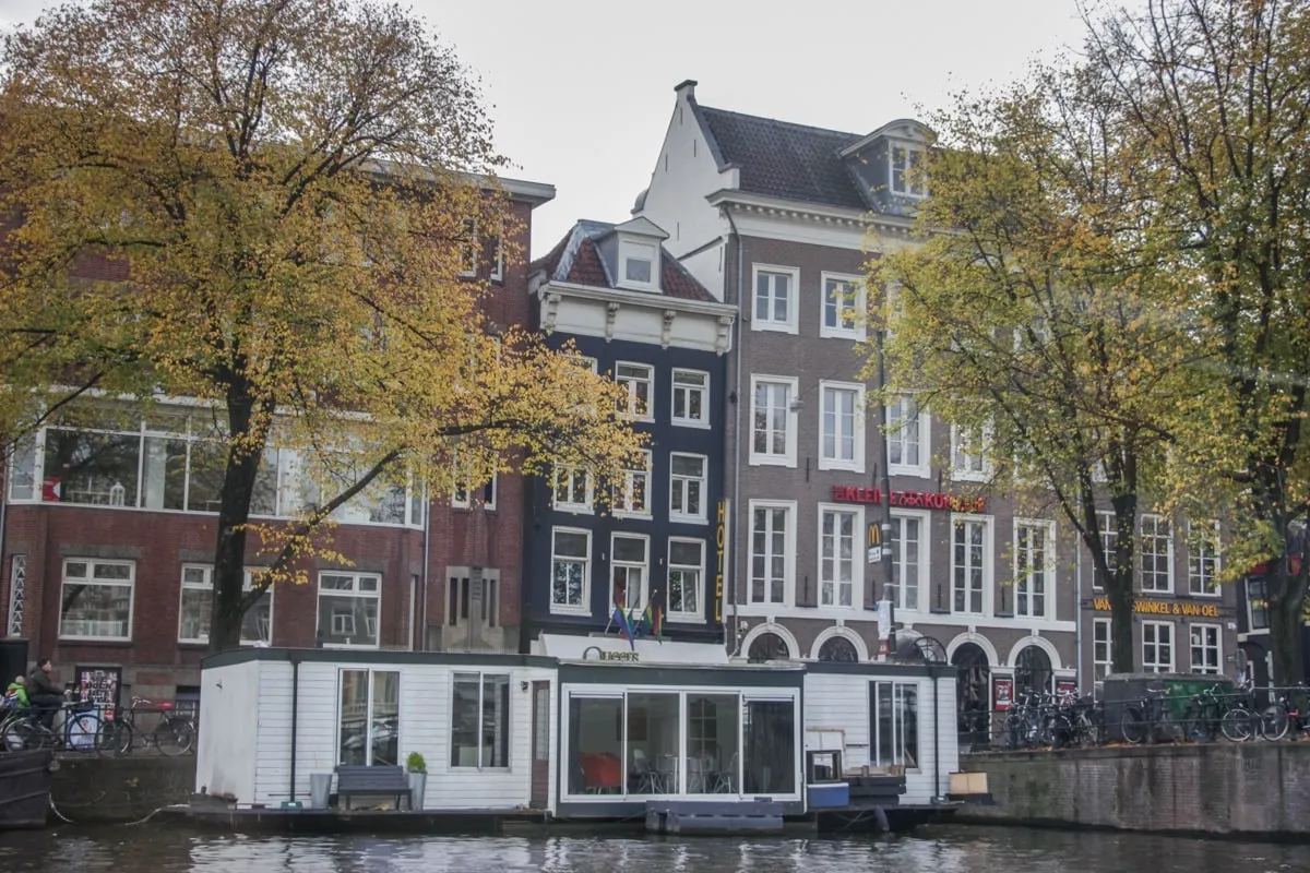 Péniche blanche amarrée devant des façades historiques