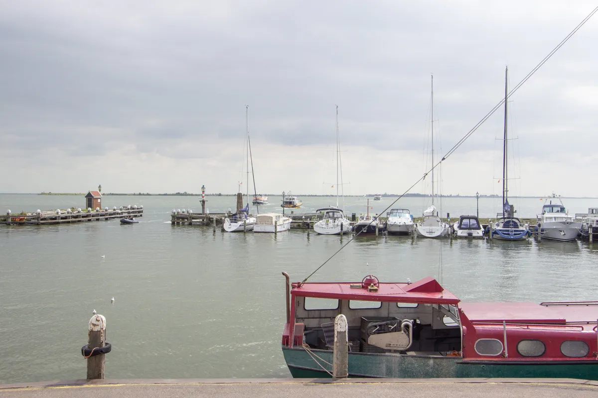 Port de plaisance avec voiliers et bateau rouge