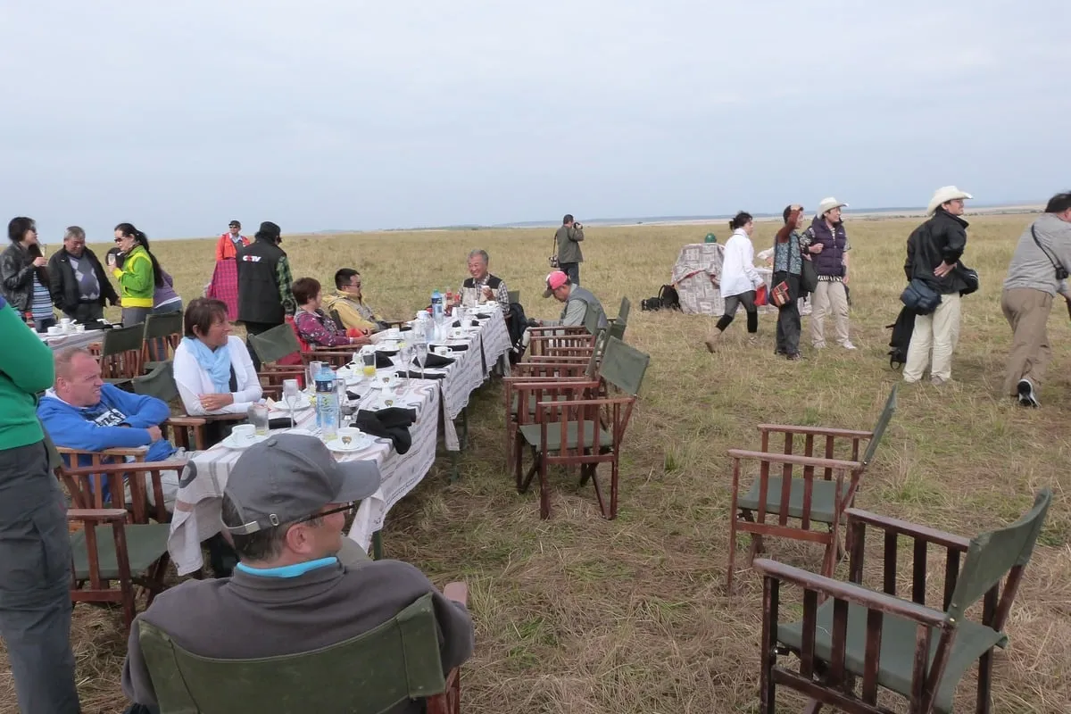 Groupe de touristes attablés pour un repas en pleine savane
