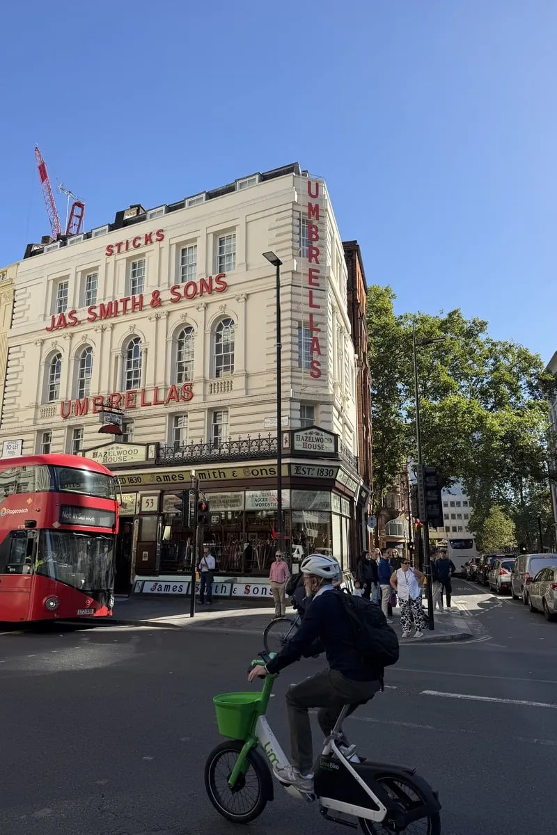 Façade blanche d'une boutique ancienne avec bus rouge au premier plan