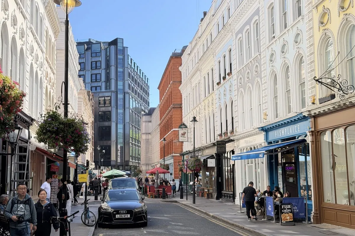 Rue commerçante animée bordée de façades blanches et restaurants