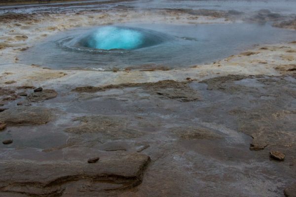 La bulle d'eau turquoise de Strokkur, au départ du jaillissement de vapeur